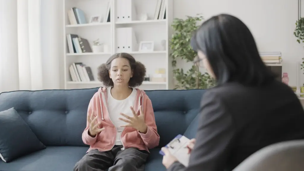 Teenage girl expresses emotions during youth therapy session in Austin.