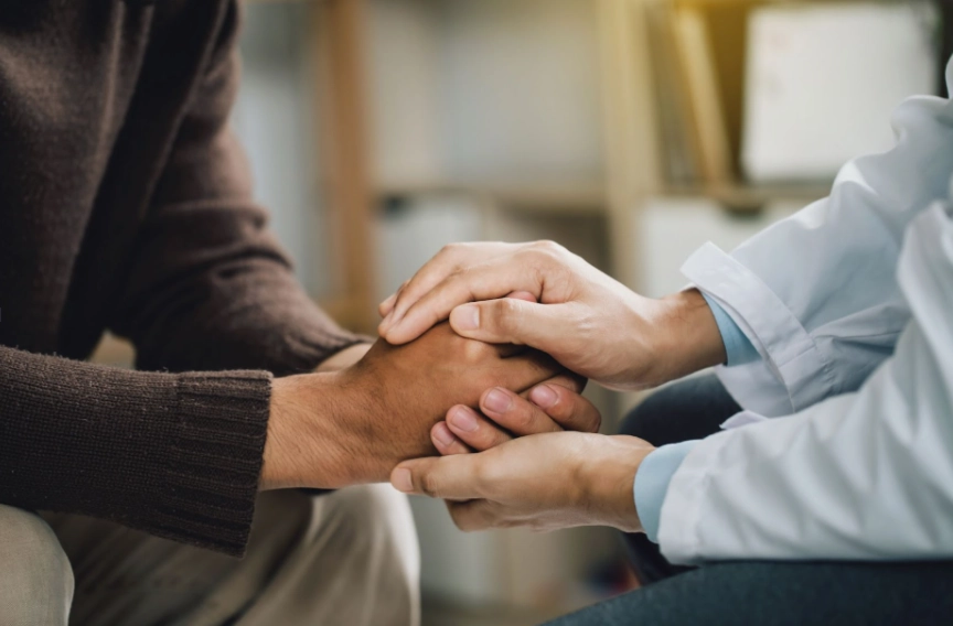 A therapist at The Timothy Center in Austin holds hands with a psychiatric patient.